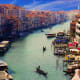 Grand Canal in Venice with historic palaces, gondolas, and waterfront buildings under blue sky